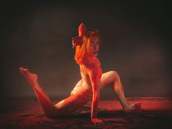 Person performing a fluid yoga transition in a dark studio